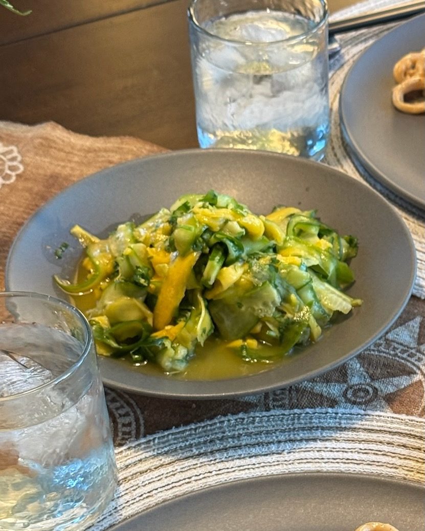 Bowl of cucumber and mango ribbons tossed with green onion, chili and a ginger lime dressing