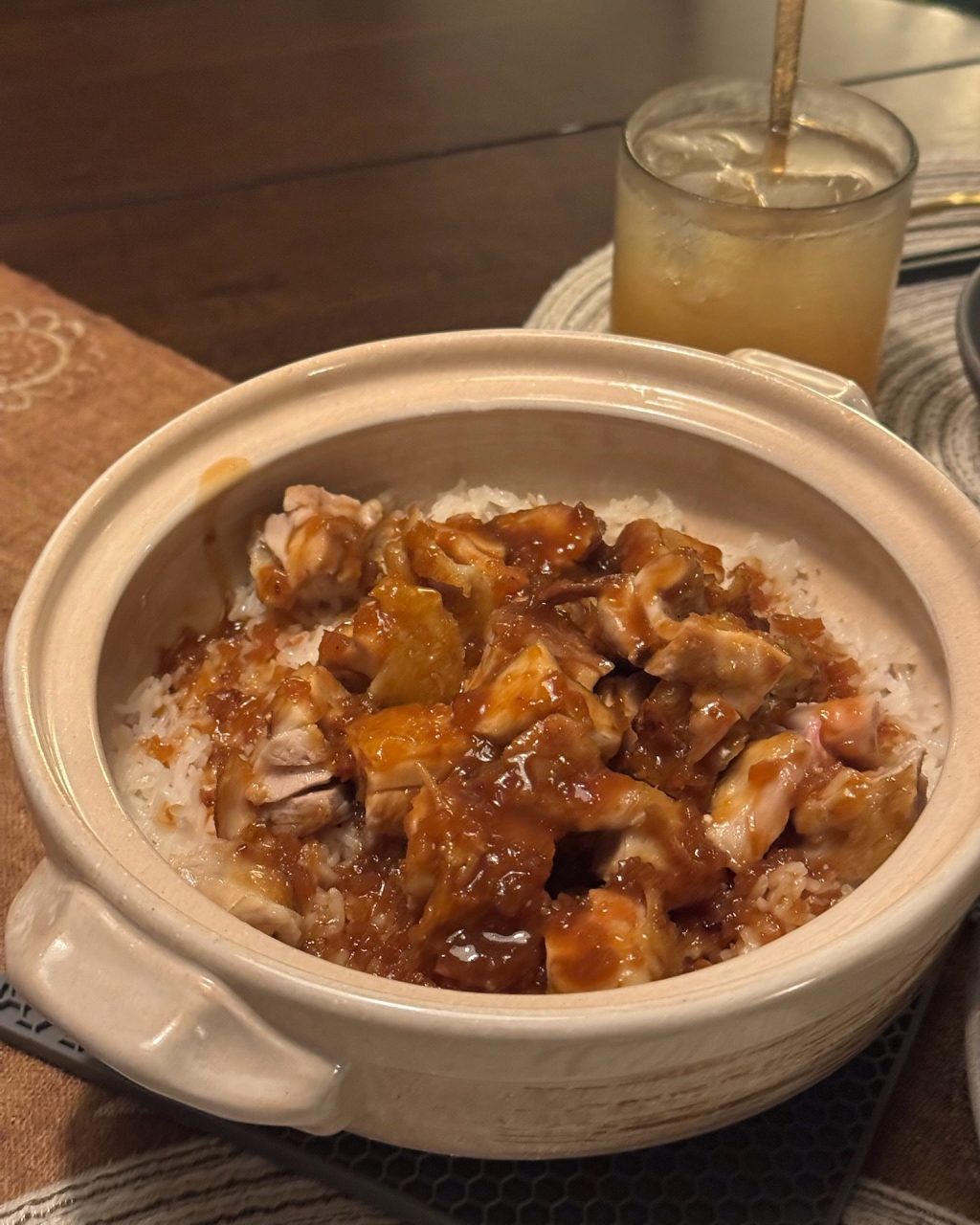 Clay pot of rice topped with crispy chicken thigh pieces and a glossy sweet miso glaze
